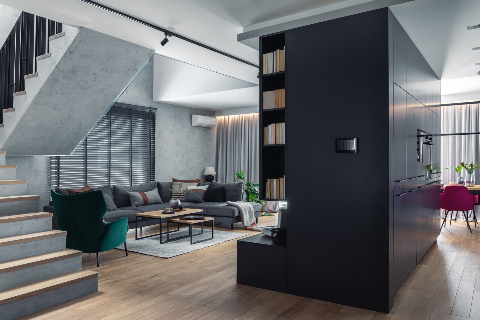 Stylish composition of living room interior with corner grey sofa, green velvet armchair, coffee table, wooden floor, design furniture and minimalist personal accessories. Modern home decor. Template.